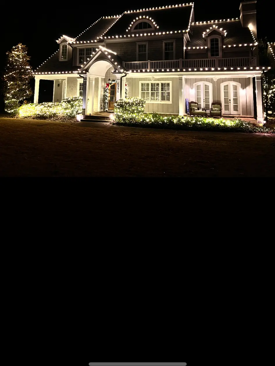 Professionally installed warm-white Christmas lights outlining an elegant North Atlanta home